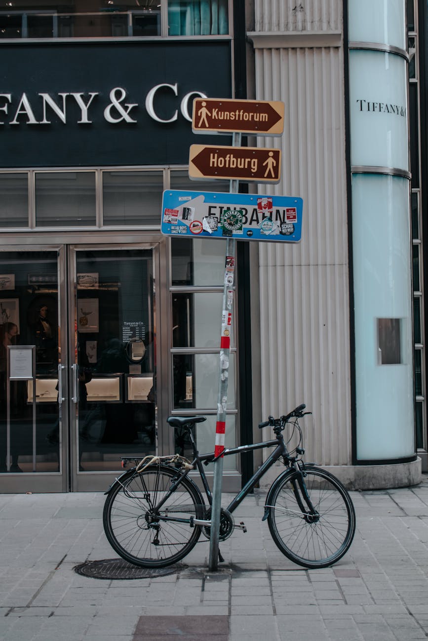 black city bicycle parked beside a street post