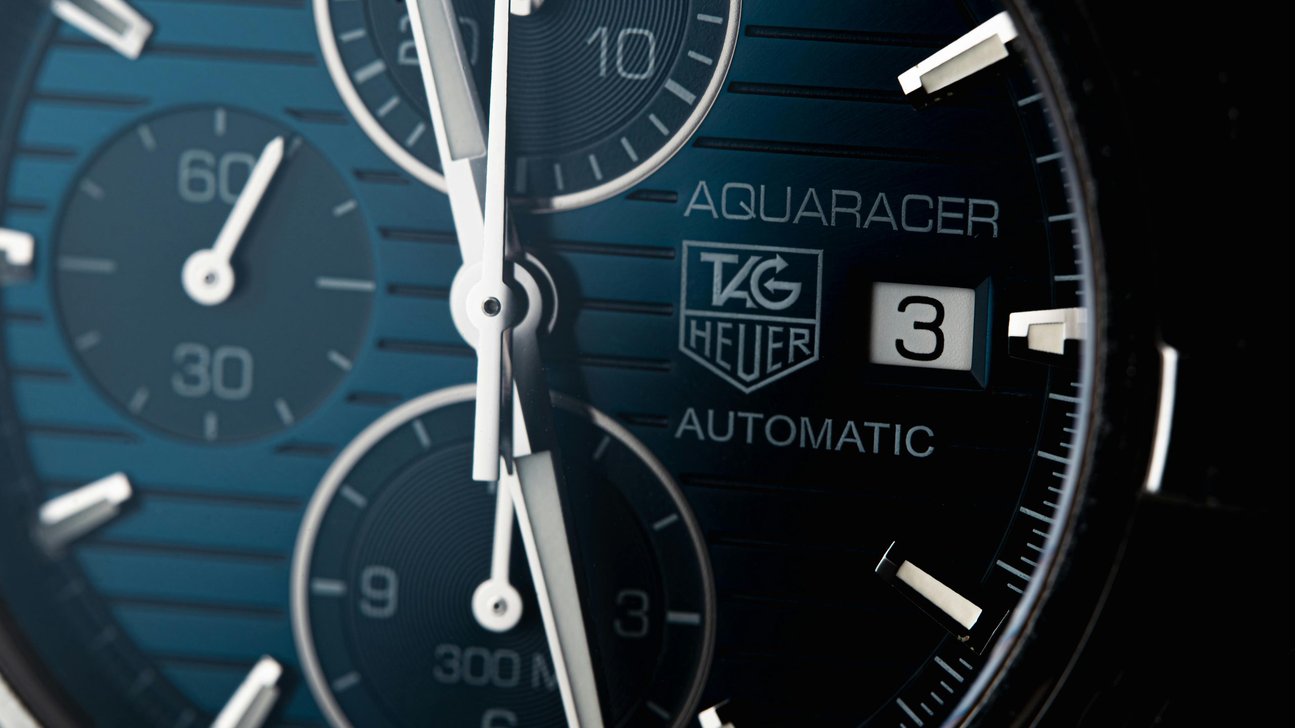 Detailed macro of a Tag Heuer Aquaracer wristwatch showcasing its elegant design.