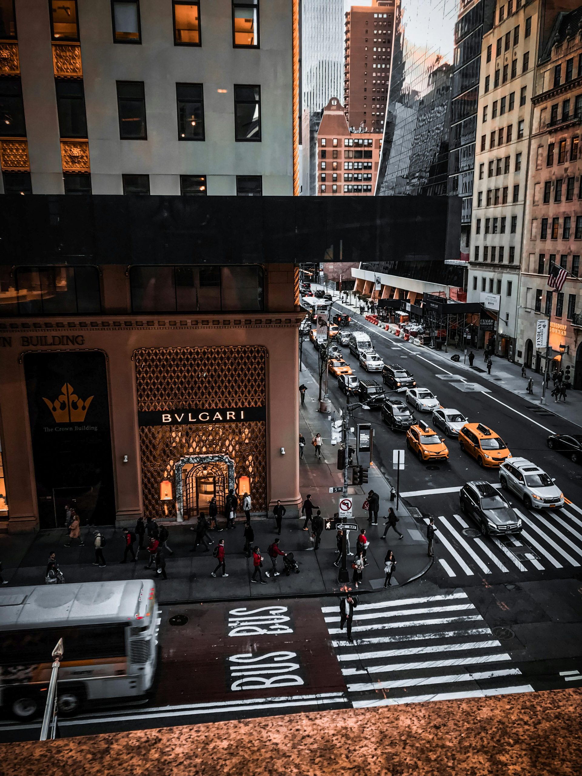 A dynamic street view of New York City featuring taxis, pedestrians, and urban architecture.